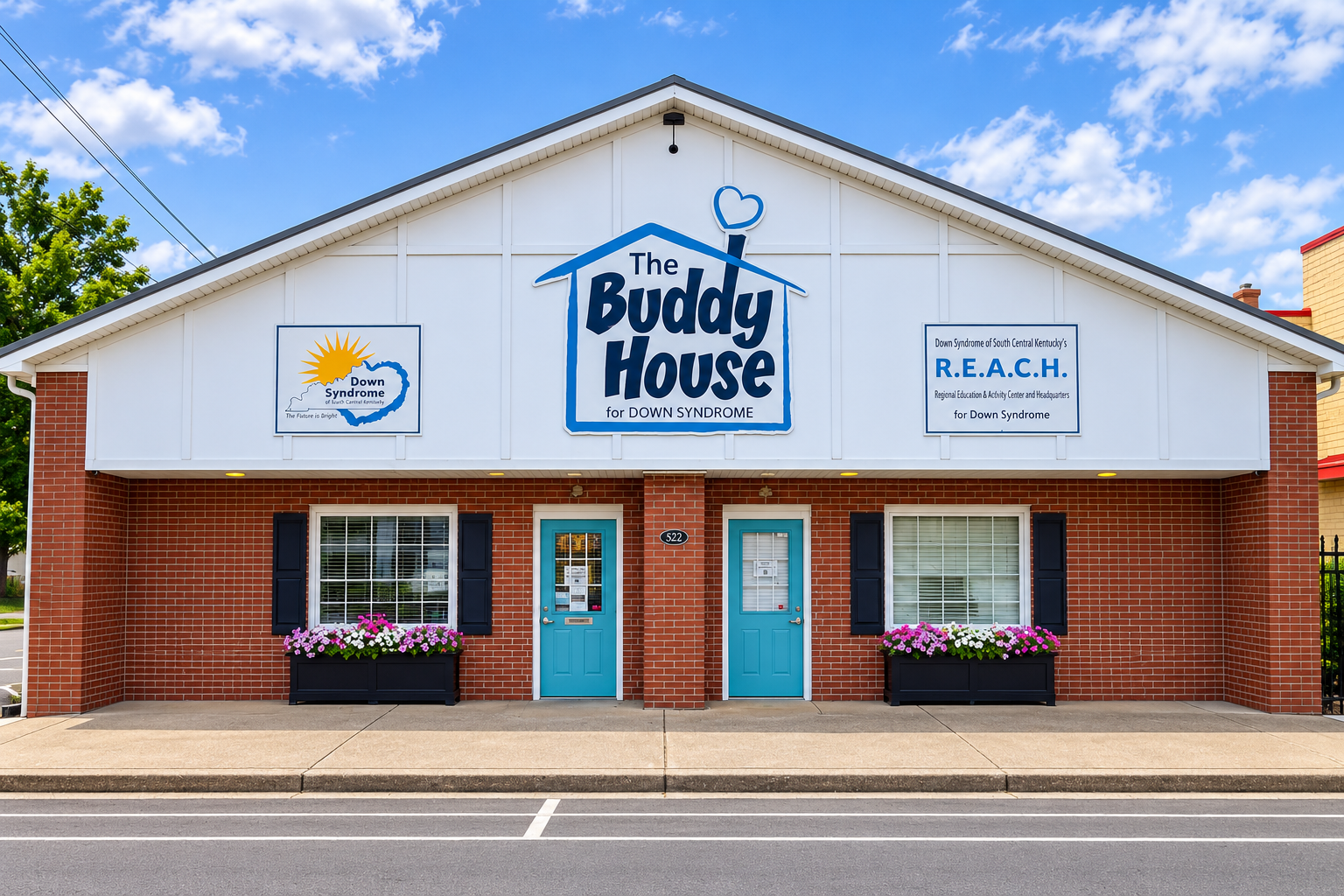 The Buddy House, a brick building with teal doors and The Buddy House for Down Syndrome sign